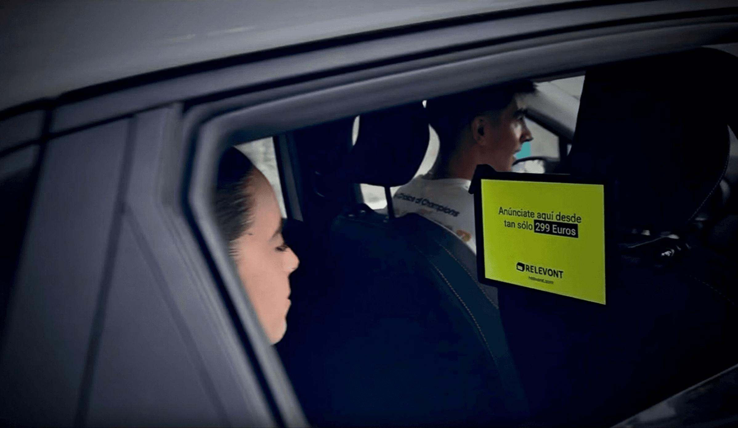 Pasajera en taxi viendo publicidad de Relevont